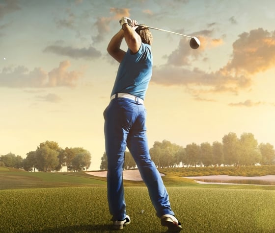 A back shot of a man playing golf during sunset