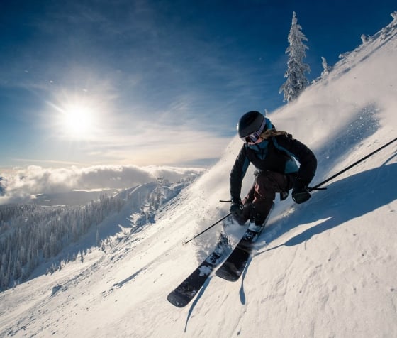 A woman snowboarding in the mountains