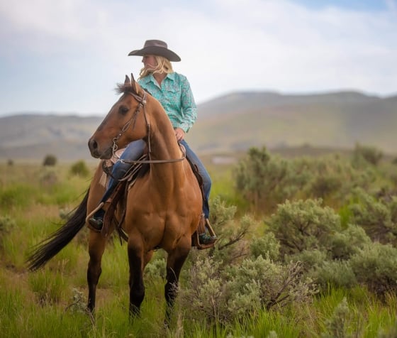 A woman riding a horse in the outdoors