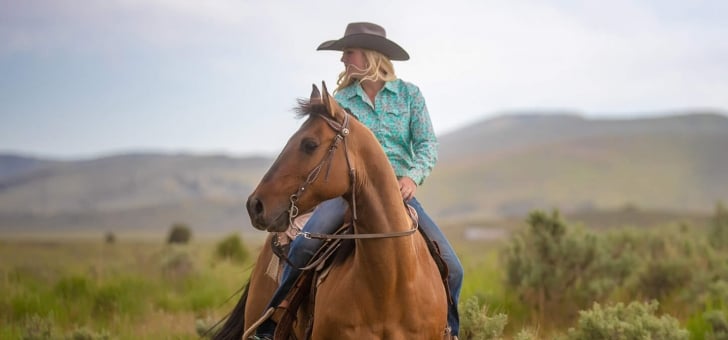 A woman riding a horse in the outdoors