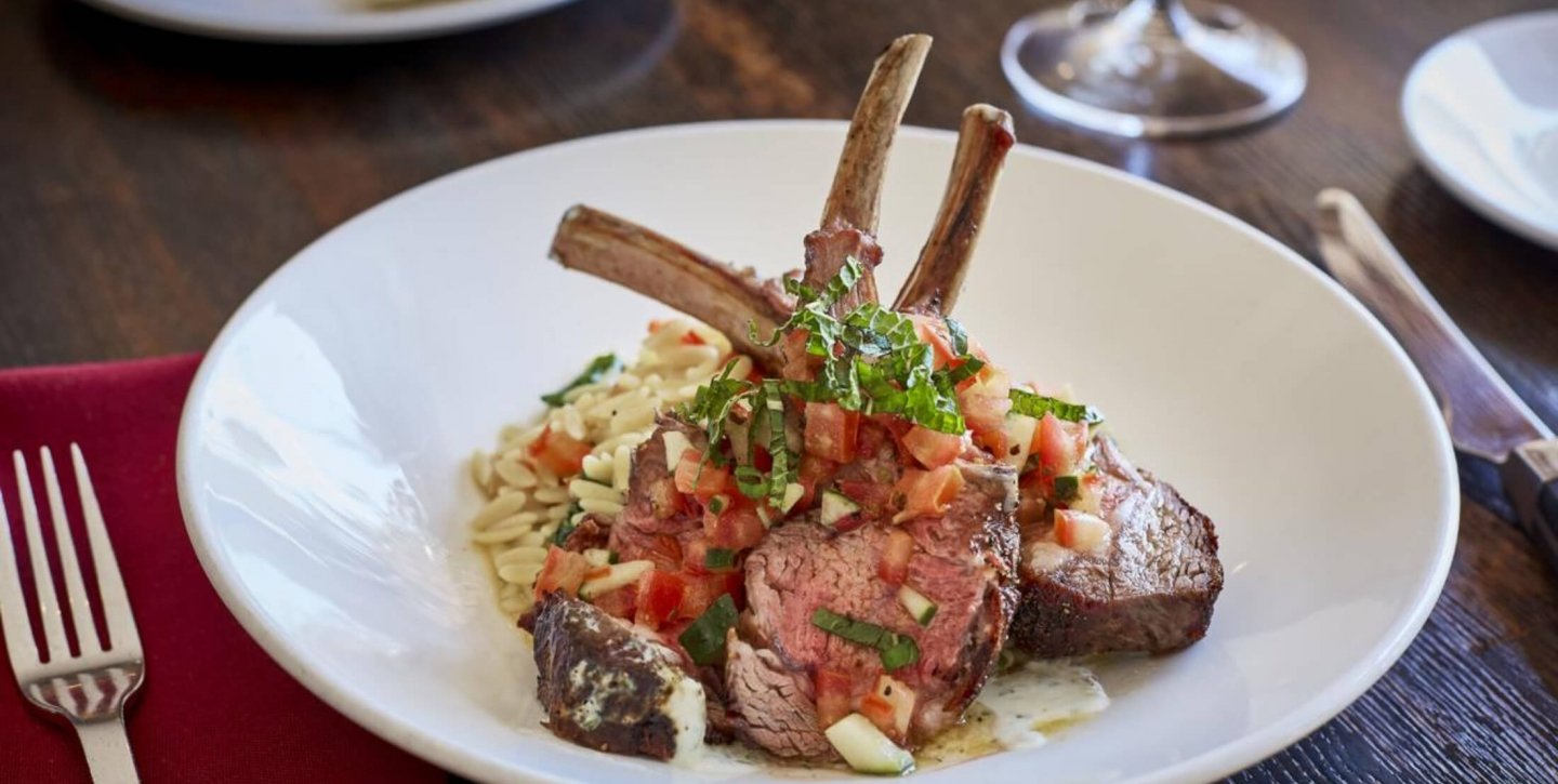 Lamb chops with brown rice garnished with herbs and tomatoes