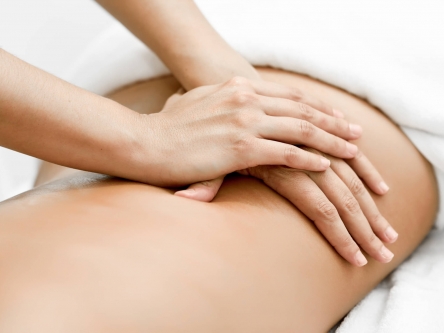 Hands pressing a woman's back during massage therapy