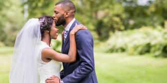 The groom kissing the bride's forehead in the outdoors