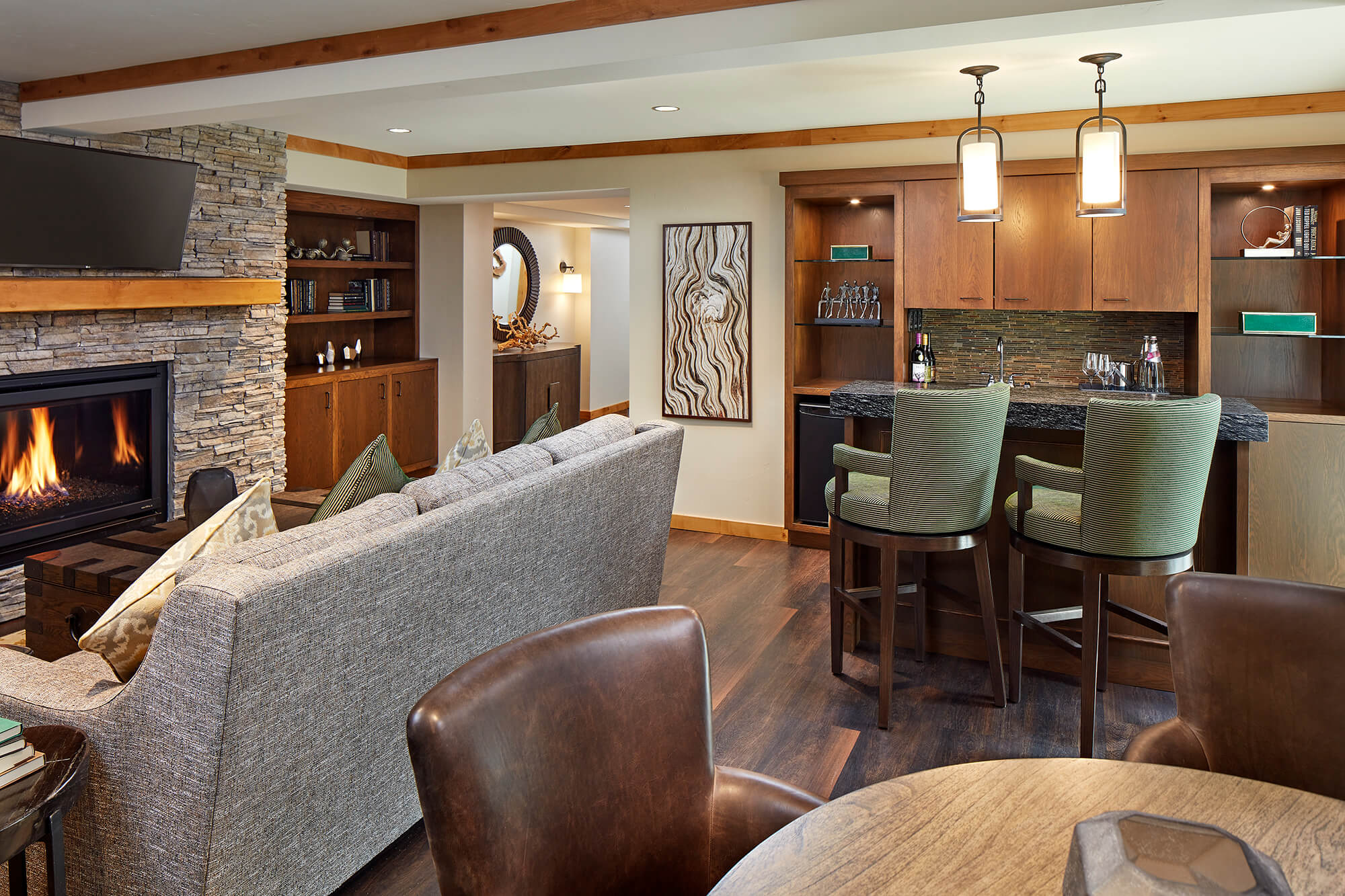 A cozy living area with a fireplace, kitchenette, and sofa.