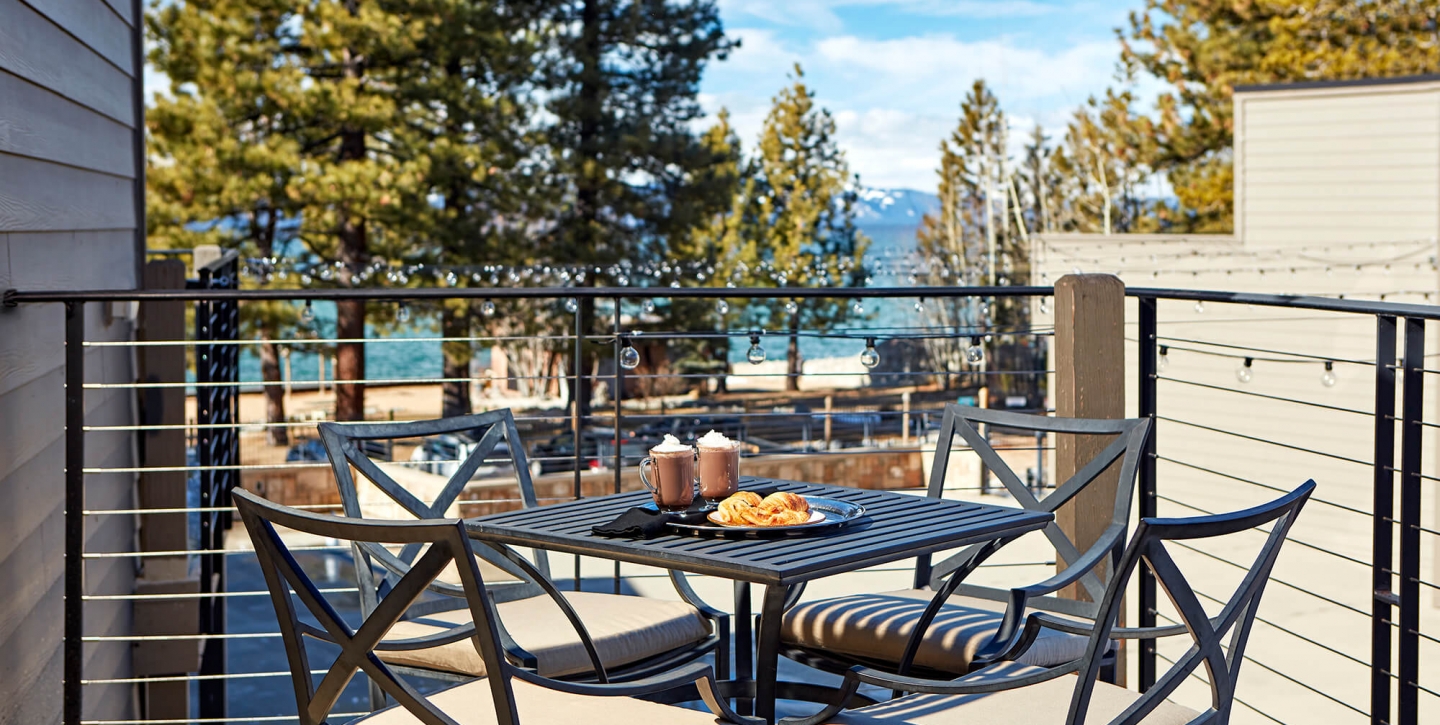 A breakfast for two overlooking Lake Tahoe from the patio balcony of a Premium Room at The Landing Resort & Spa