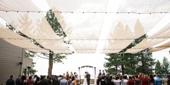 A wedding ceremony taking place with the bride groom, and guests