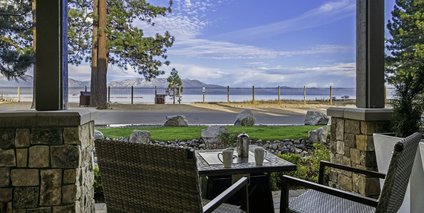 Woven patio chairs facing the coffee table overlooking the lake and mountain view