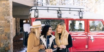 Friends laughing with champagne outside The Landing Tahoe