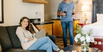 Couple relaxing in suite with wine and charcuterie board