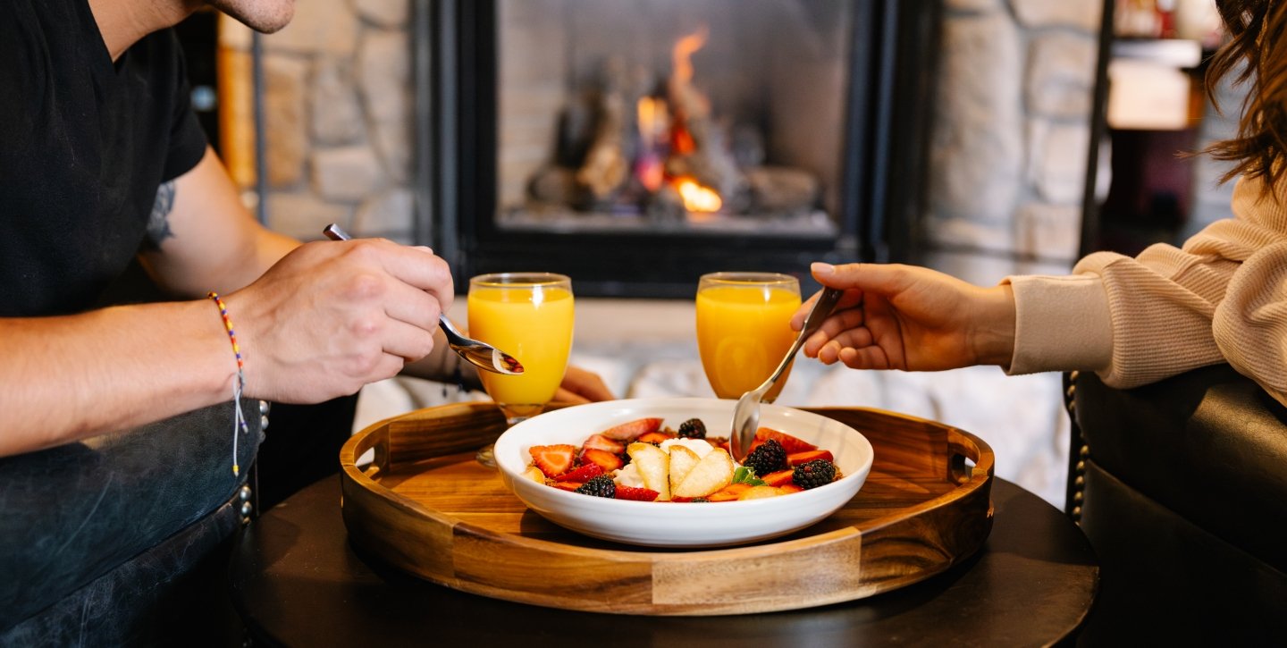 Couple enjoying breakfast in front of the fire