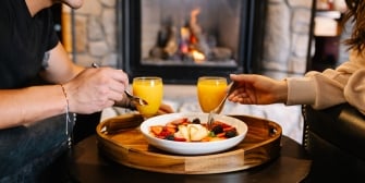 Couple enjoying breakfast in front of the fire