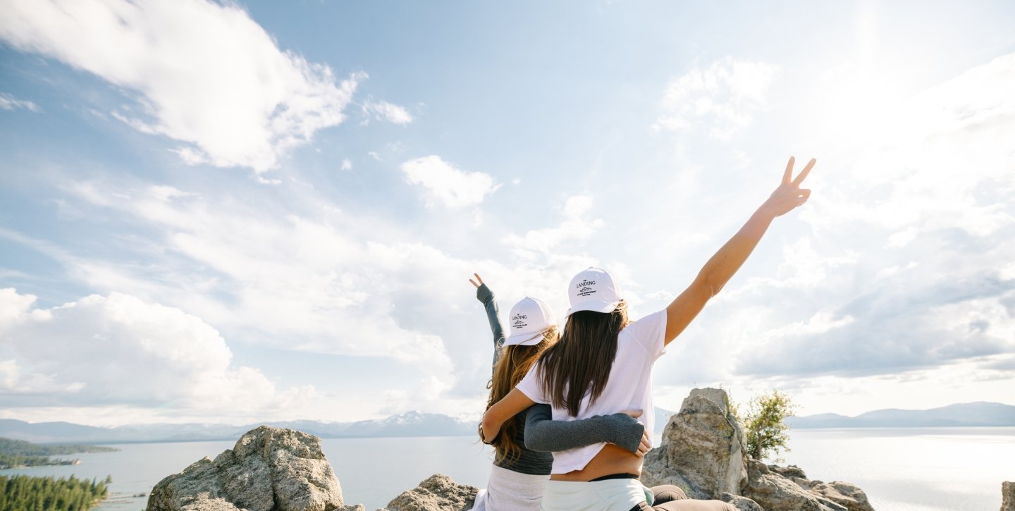 Posed hiking photo on rocks with lake backdrop