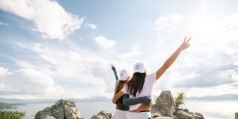 Posed hiking photo on rocks with lake backdrop