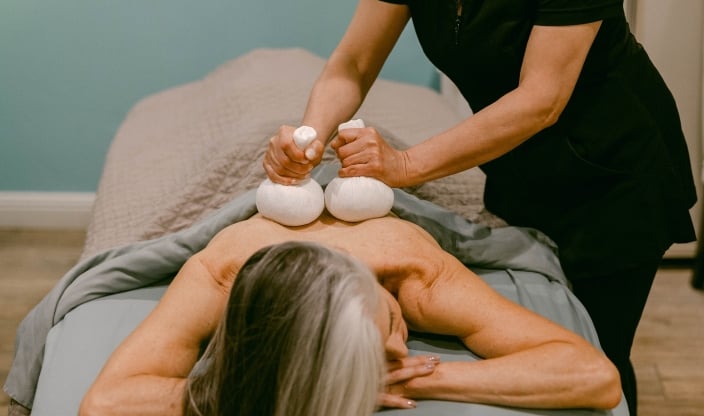 Woman receiving Herbal Poultice massage