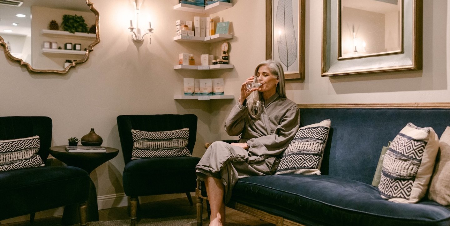 Woman drinking water in spa waiting room