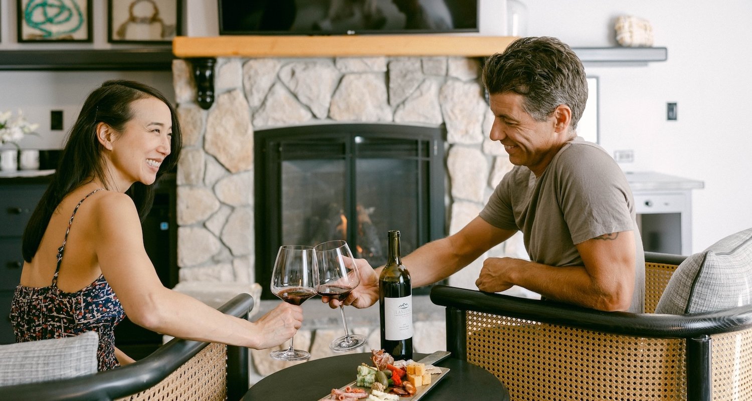 Couple in their room enjoying wine and a charcuterie board