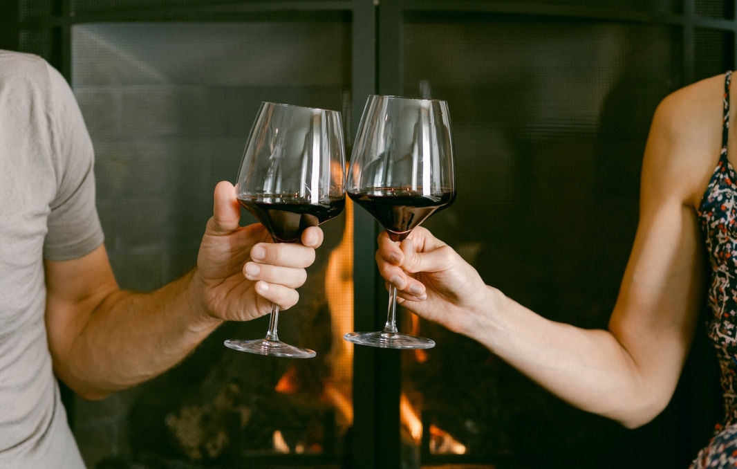 Two arms holding two glasses of wine