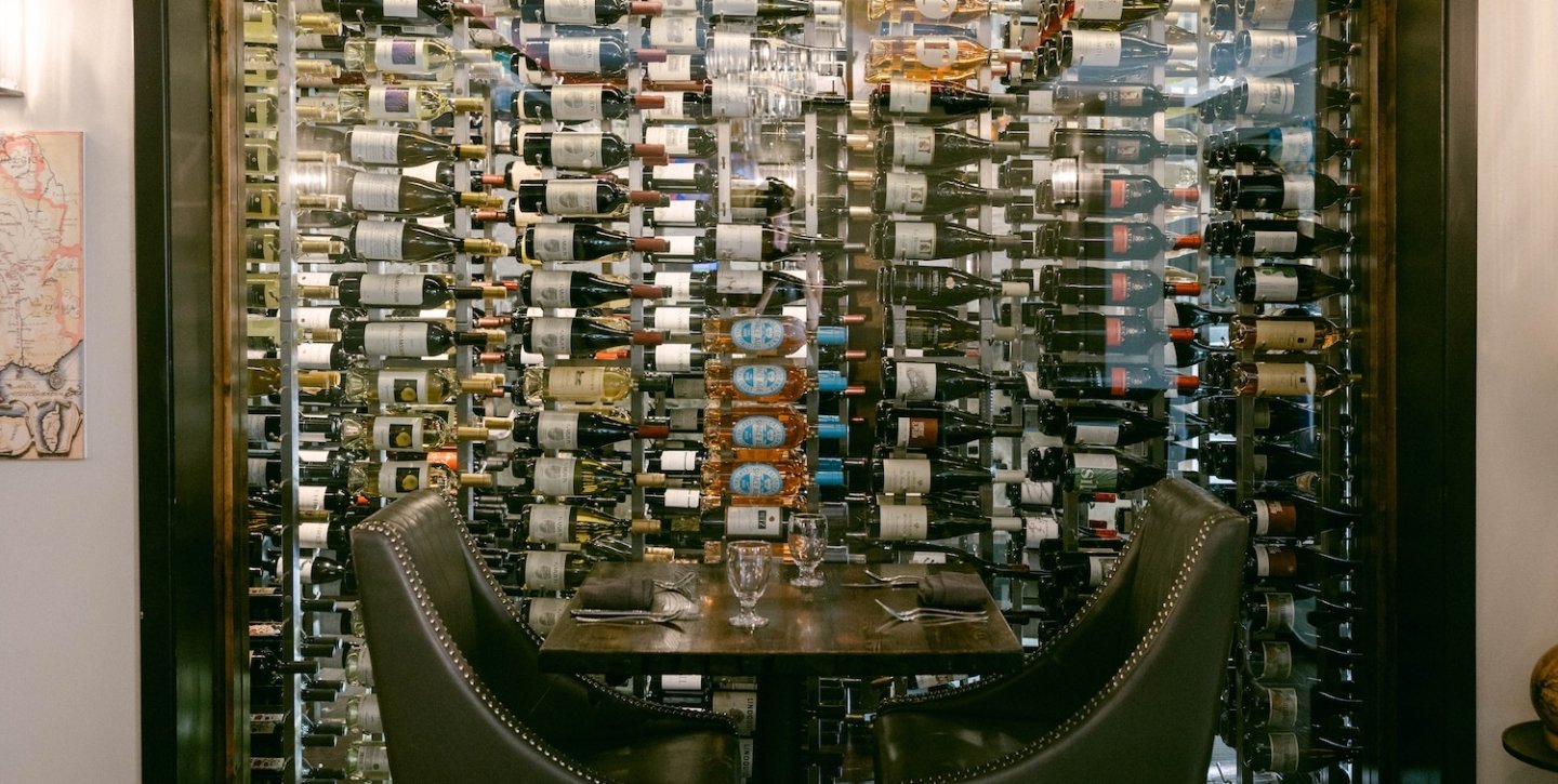 Table with two seats with wine bottles in the back