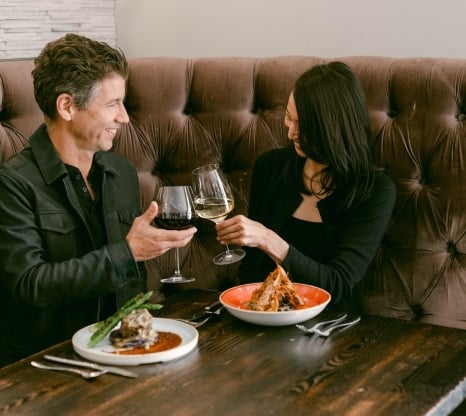 Couple clinking glasses while having dinner
