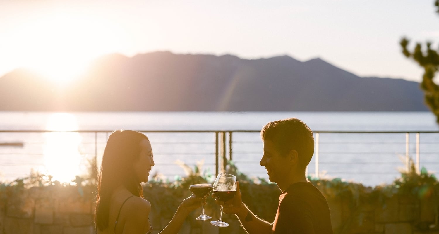Two people clinking wine glasses outside
