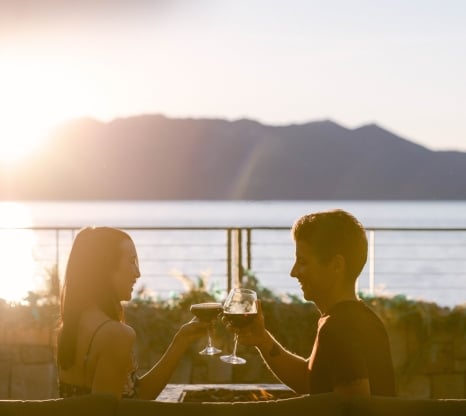 Two people clinking wine glasses outside