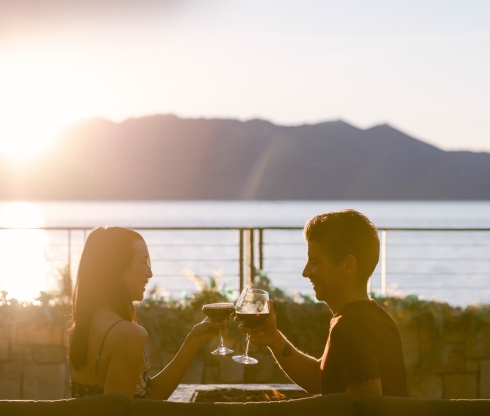 Two people clinking wine glasses outside