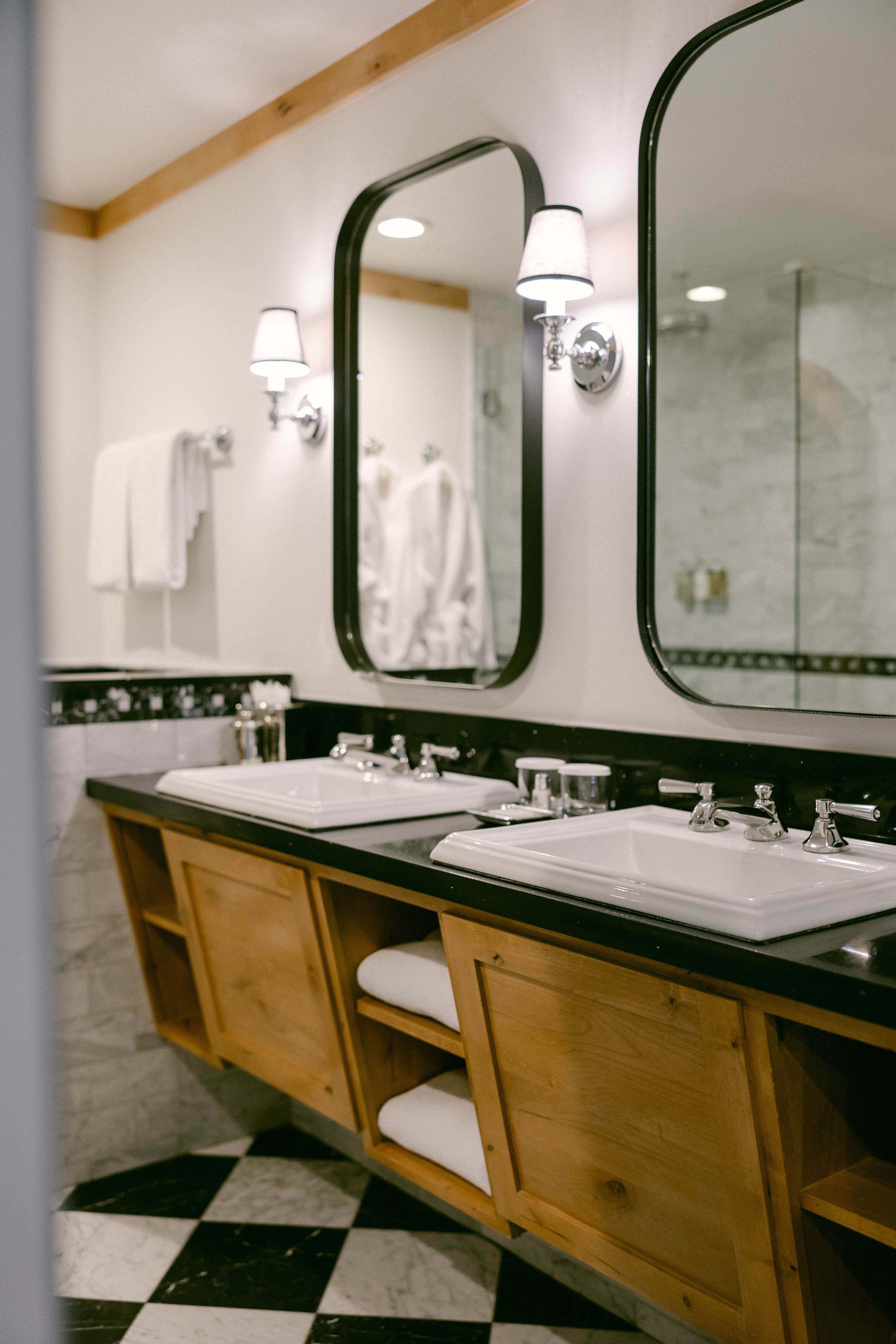 A bathroom with a double vanity, two large mirrors, and white sinks.