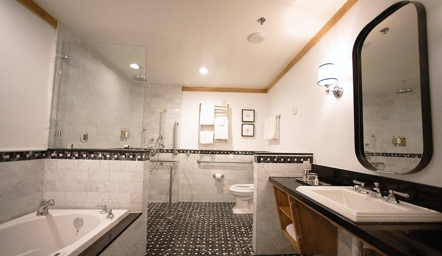 A clean and modern bathroom with a bathtub, shower, toilet, and sink.