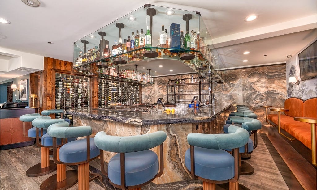 A bar with a marble countertop and blue stools