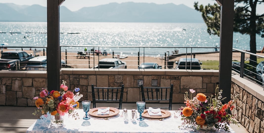A romantic outdoor dining setup with a lake view.